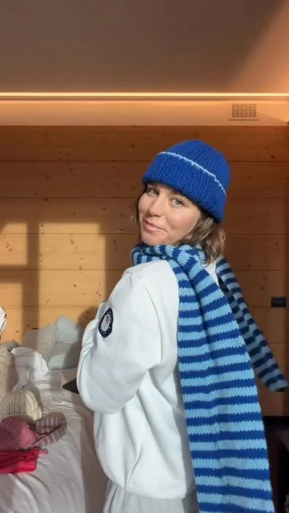 Olympic halfpipe snowboarder Maddie Mastro wearing her knitting project featuring bright, multicolored stripes during the Winter Olympics