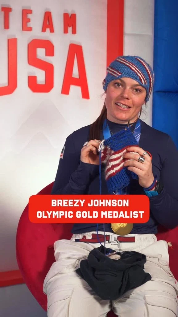 Olympic skier Breezy Noble Johnson holding knitted work-in-progress with multicolored yarn.